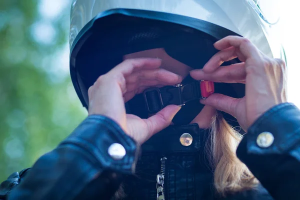 Frau setzt Motorradhelm auf und schnallt Verschluss an — Stockfoto