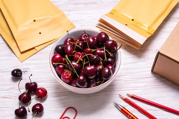 Bubble Envelopes on wooden table with cherry, summer concept — Stock Photo, Image