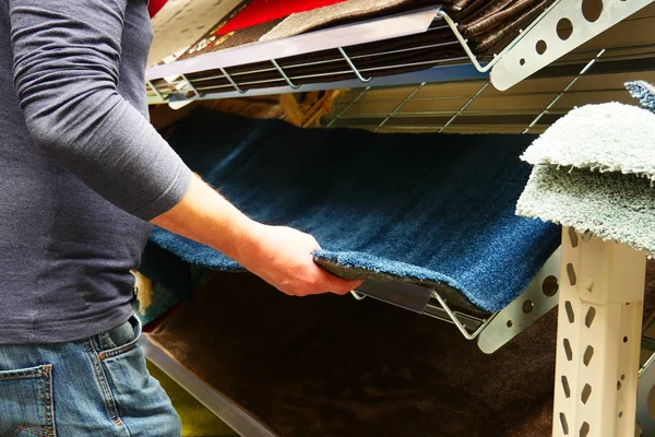 Hombre elegir una alfombra nueva en la tienda — Foto de Stock