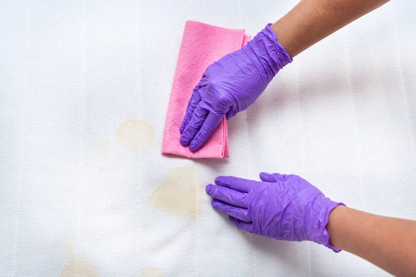 Kadınlar kirli bir yatağı lekelerle temizliyor Telifsiz Stok Imajlar