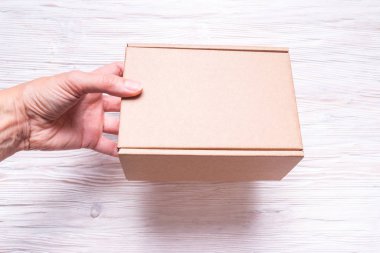 Ahşap arka plan üzerinde saplı karton kutu