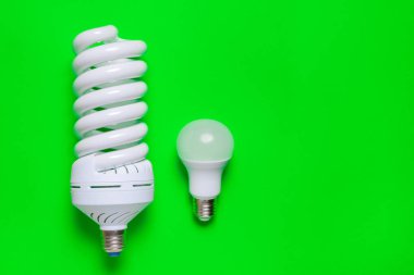 Yeşil arkaplanda farklı enerji tasarrufu lambası kümesi