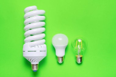 Yeşil arkaplanda farklı enerji tasarrufu lambası kümesi