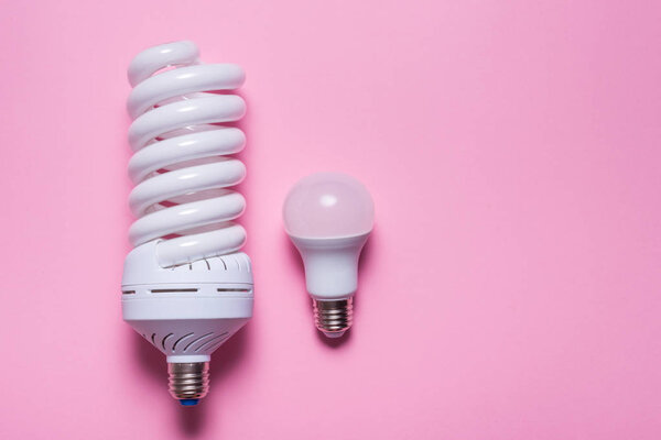 Set of different energy saving lamp on pink background