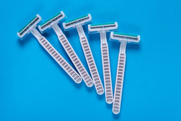 Lot of plastic disposable razor on blue background