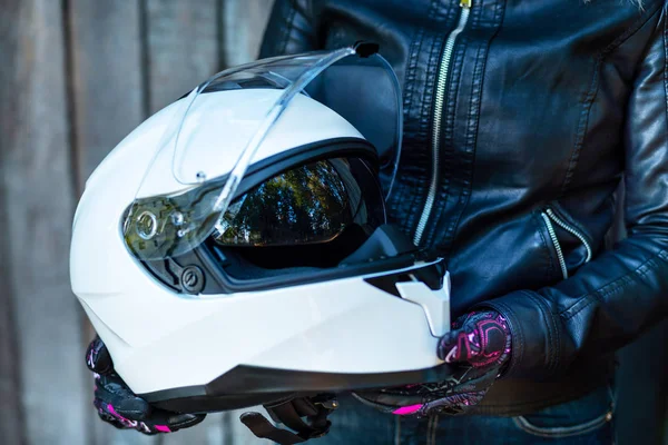 Mujer en chaqueta de cuero sostiene casco de motocicleta — Foto de Stock