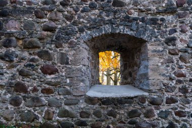 Sonbahar manzarasında taş duvardaki pencere