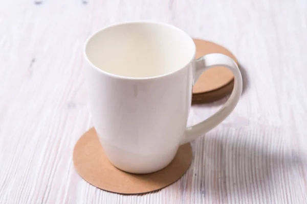 Белый фарфоровый чай из чашки кофе на круглом картоне Круглое побережье — стоковое фото