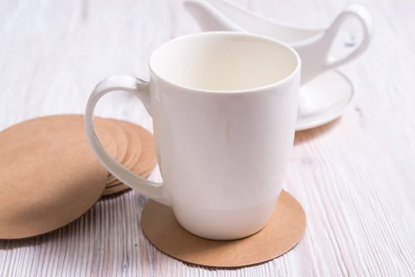 Белый фарфоровый чай из чашки кофе на круглом картоне Круглое побережье — стоковое фото