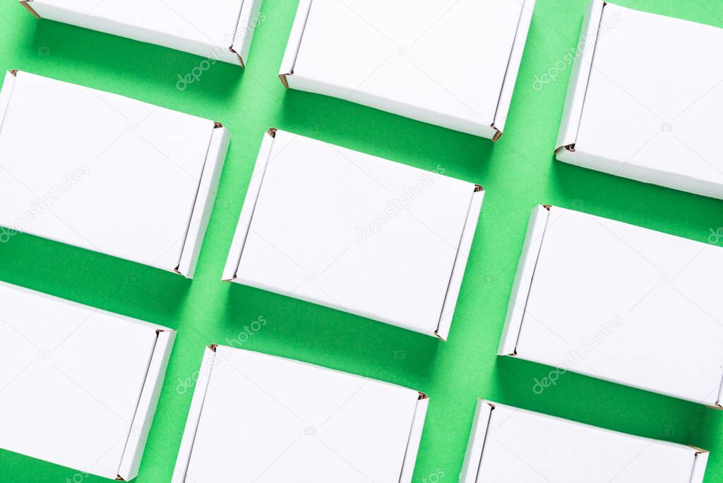 Lot of square carton boxes on green background