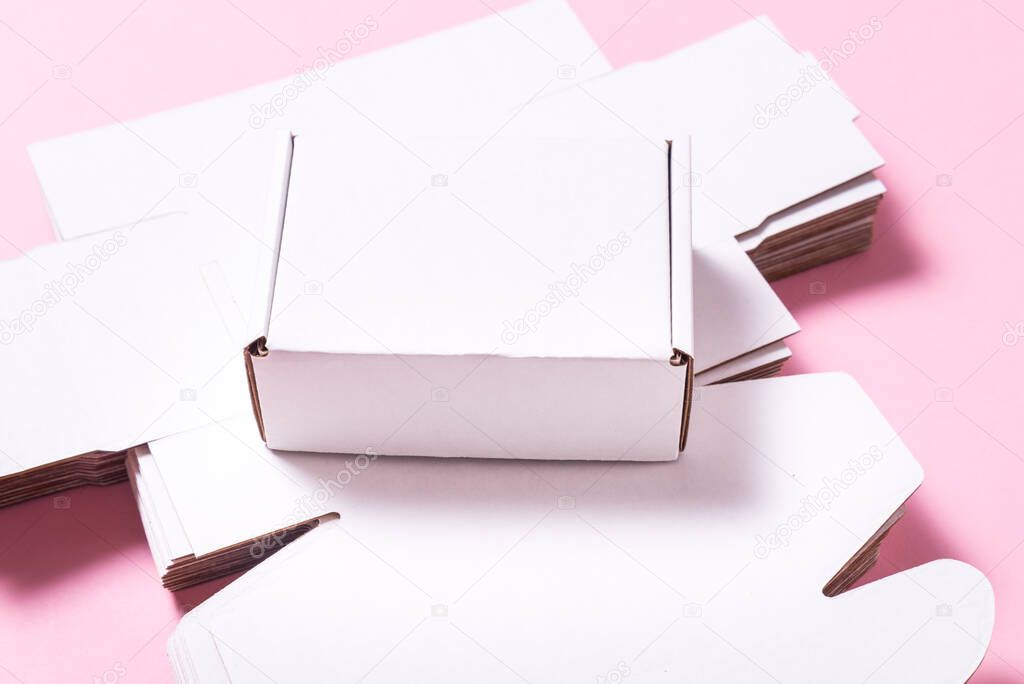 Lot of square carton boxes on pink background, cutted