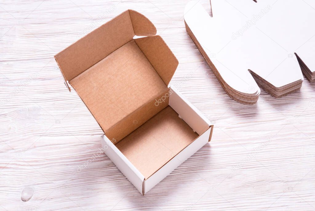 White square carton box on wooden background, cutted