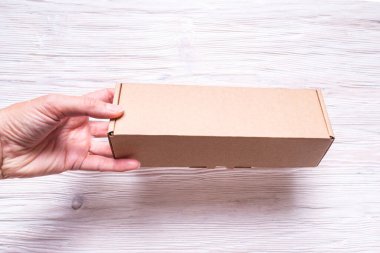 Ahşap arka plan üzerinde saplı karton kutu