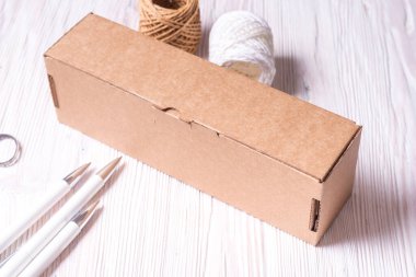 Kahverengi karton kutu, tahta masanın üstünde çanta.