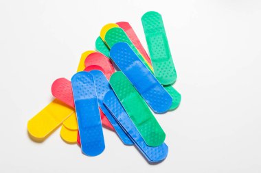 Beyaz arkaplanda renkli ilk yardım alçıları