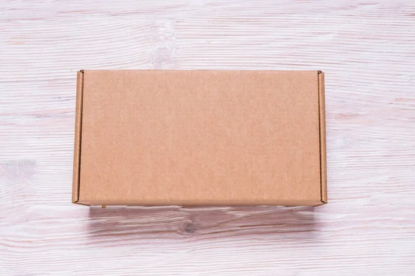 Brown cardboard flat postal box, case, on wooden table