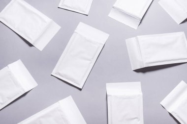 Gri arkaplanda bir sürü beyaz baloncuklu zarf var.