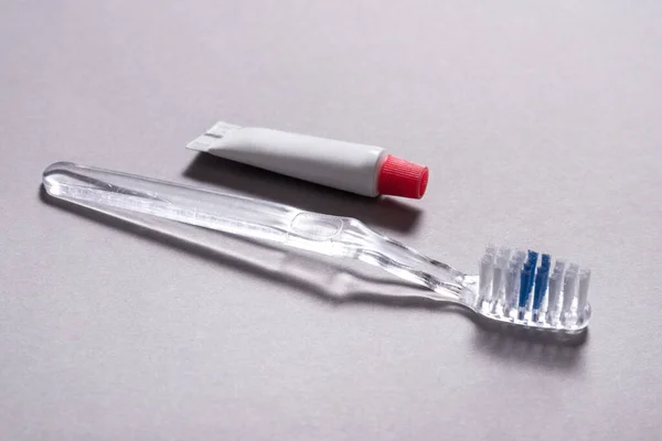 歯磨き粉の小さなチューブと使い捨て歯ブラシを使用する — ストック写真