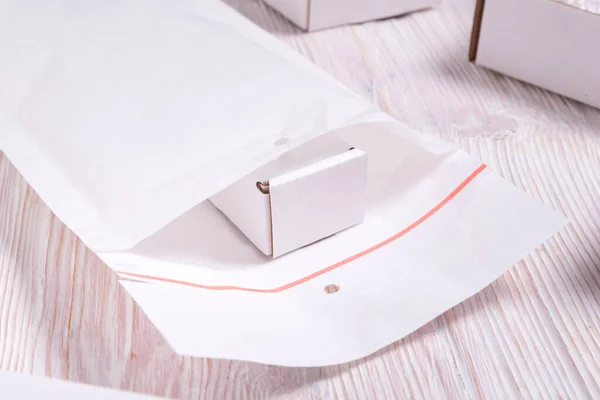 Tahta Masada Bir Sürü Beyaz Baloncuk Zarf Karton Kutu Var — Stok fotoğraf
