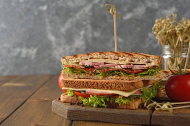 Salatalık, peynir ve kahverengi bir arka plan üzerinde jambon ile sandviç