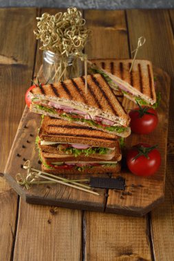 Salatalık, peynir ve kahverengi bir arka plan üzerinde jambon ile sandviç