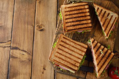 Salatalık, peynir ve kahverengi bir arka plan üzerinde jambon ile sandviç