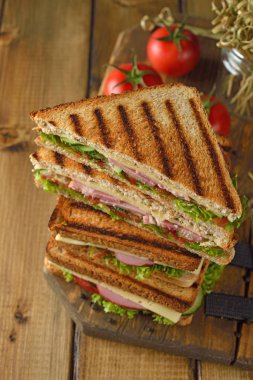 Salatalık, peynir ve kahverengi bir arka plan üzerinde jambon ile sandviç