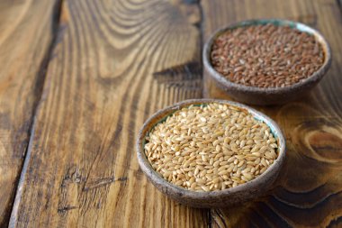 Ahşap arka plan üzerinde beyaz ve kahverengi keten tohumu