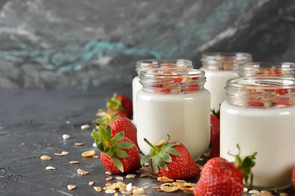 Gri bir arka plan üzerinde cam kavanozlara Doğal yoğurt