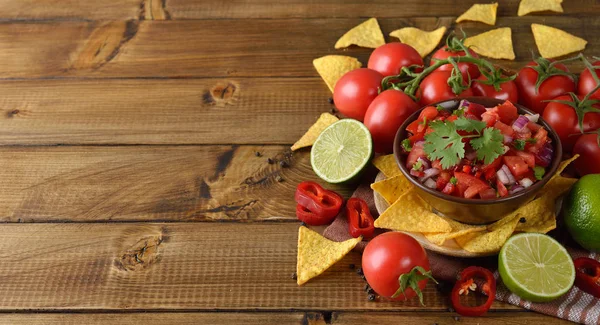 Kahverengi bir arka plan üzerinde Mısır nachos domates salsa