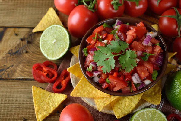 Kahverengi bir arka plan üzerinde Mısır nachos domates salsa