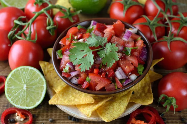 Kahverengi bir arka plan üzerinde Mısır nachos domates salsa