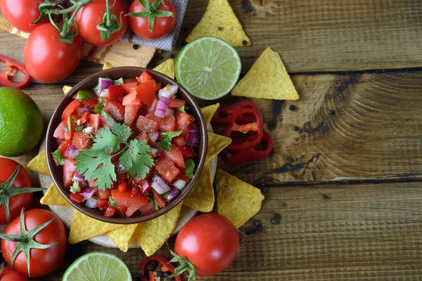 Kahverengi bir arka plan üzerinde Mısır nachos domates salsa