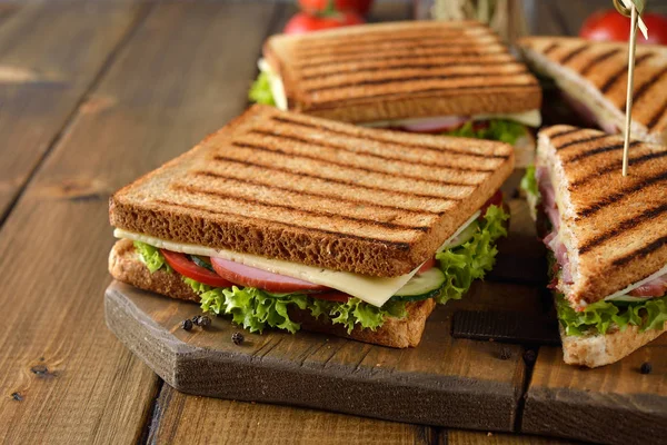 Salatalık, peynir ve kahverengi bir arka plan üzerinde jambon ile sandviç