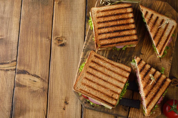 Salatalık, peynir ve kahverengi bir arka plan üzerinde jambon ile sandviç