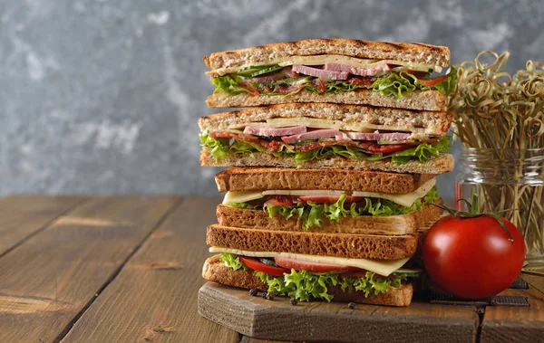 Salatalık, peynir ve kahverengi bir arka plan üzerinde jambon ile sandviç