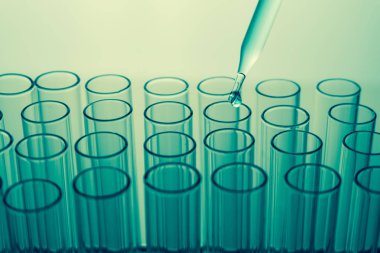 Laboratuvardaki deney tüpünün üzerinde borular, laboratuvar deneyleri için kimyasal örnekler bırakıyor.