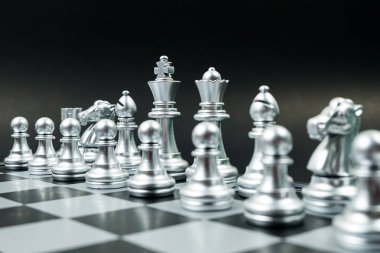Gemide gümüş satranç takımının satırı, siyah arka plan