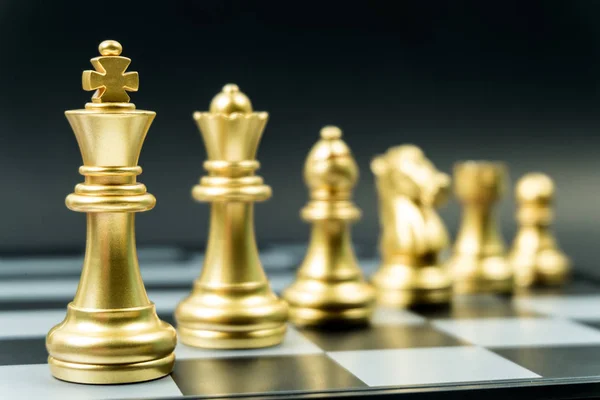Fila de equipo de ajedrez de oro a bordo, fondo negro —  Fotos de Stock