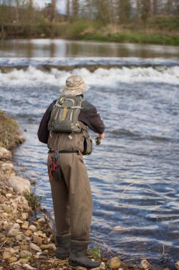 Genç adam flyfishing Nehri üzerinde