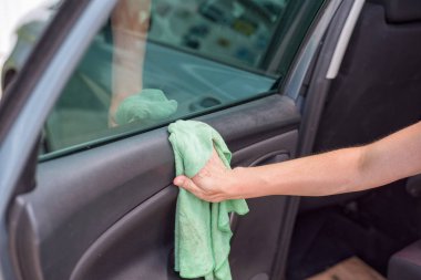 Genç kadın mikrofiber bezle araba iç temizlik. Araba Detaylandırma.