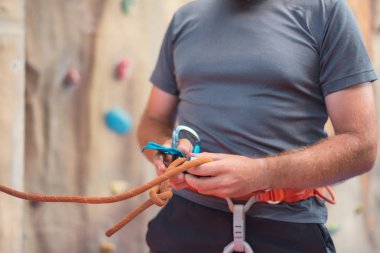 Emniyet kemeri takıyor ve ekipman kapalı, yakın çekim görüntü tırmanma duvarı dağcı