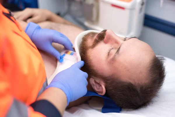 Emergency doctor putting a cervical collar to a patient in the ambulance