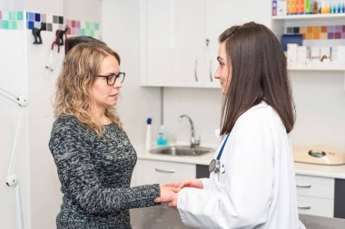 Doktor hastanın el ele tutuşarak, yardım ve empati kavramı.