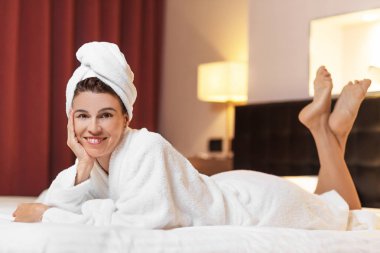 Genç kadın otel odasında, bir duş aldıktan sonra rahat yalan bornoz
