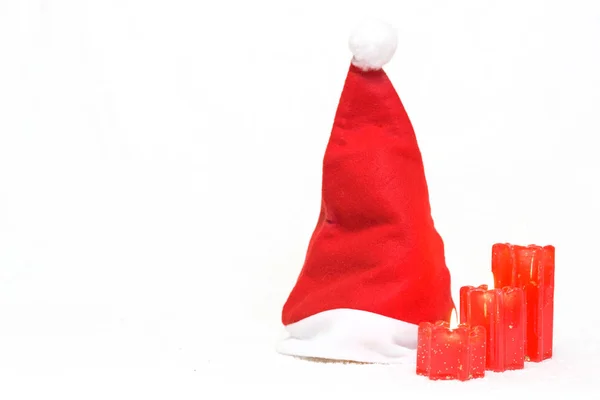 Weihnachtsmann Mütze Und Rote Kerzen Auf Weißem Isoliert — Stockfoto