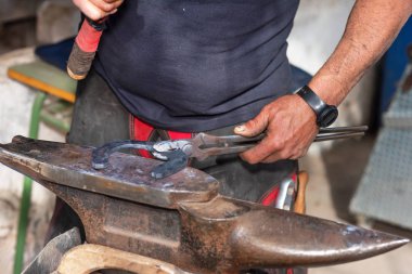 At nalı yapma örs üzerinde çalışan demirci.