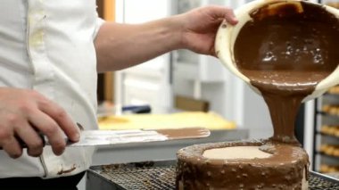 Profesyonel pasta Şef boşalırcasına erimiş çikolata kek üzerine. Şekerleme ve tatlılar.