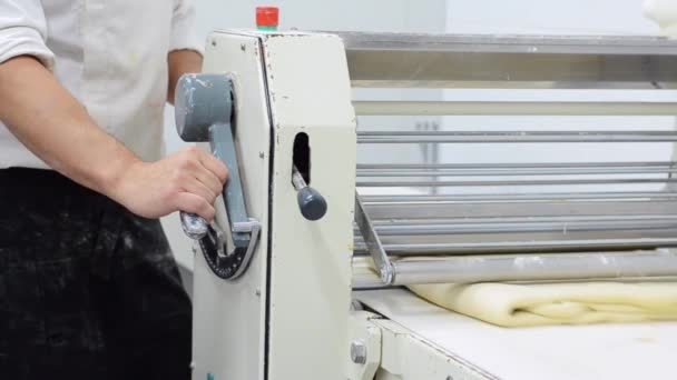 Baker med degen sheeter maskin som producerar croissanter degen på bageriet. — Stockvideo