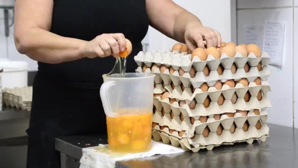 Konditor bricht Eier, um den Kuchen zuzubereiten — Stockvideo